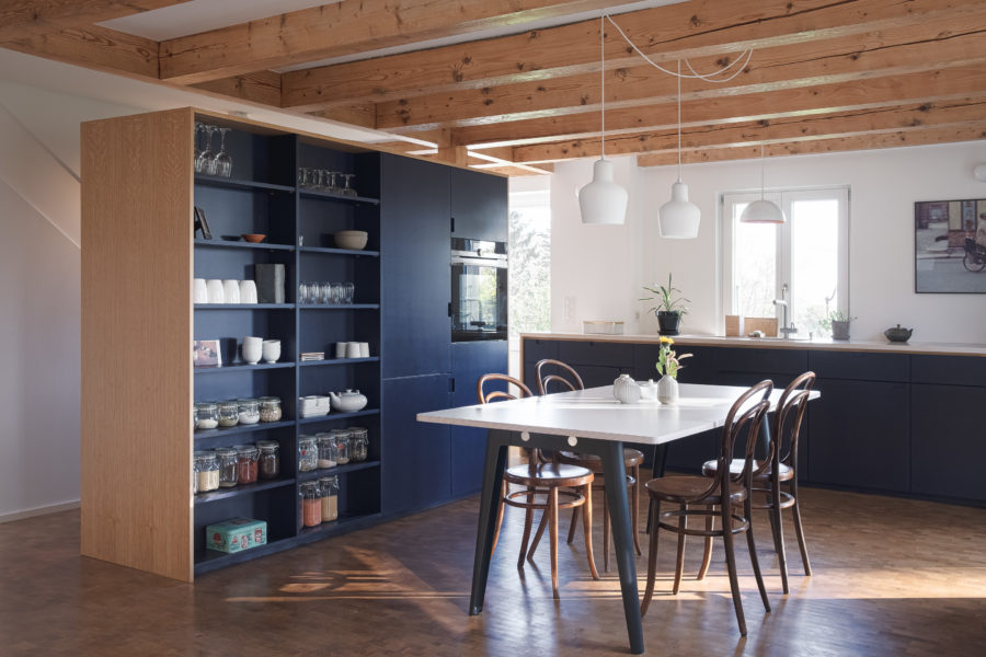 Cuisine en bois bleu foncé avec poutres en bois.