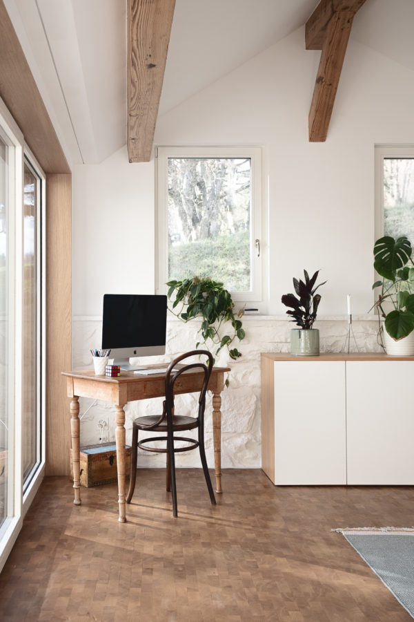Bureau dans un coin de la maison avec de la lumière naturelle, où le bois prédomine.